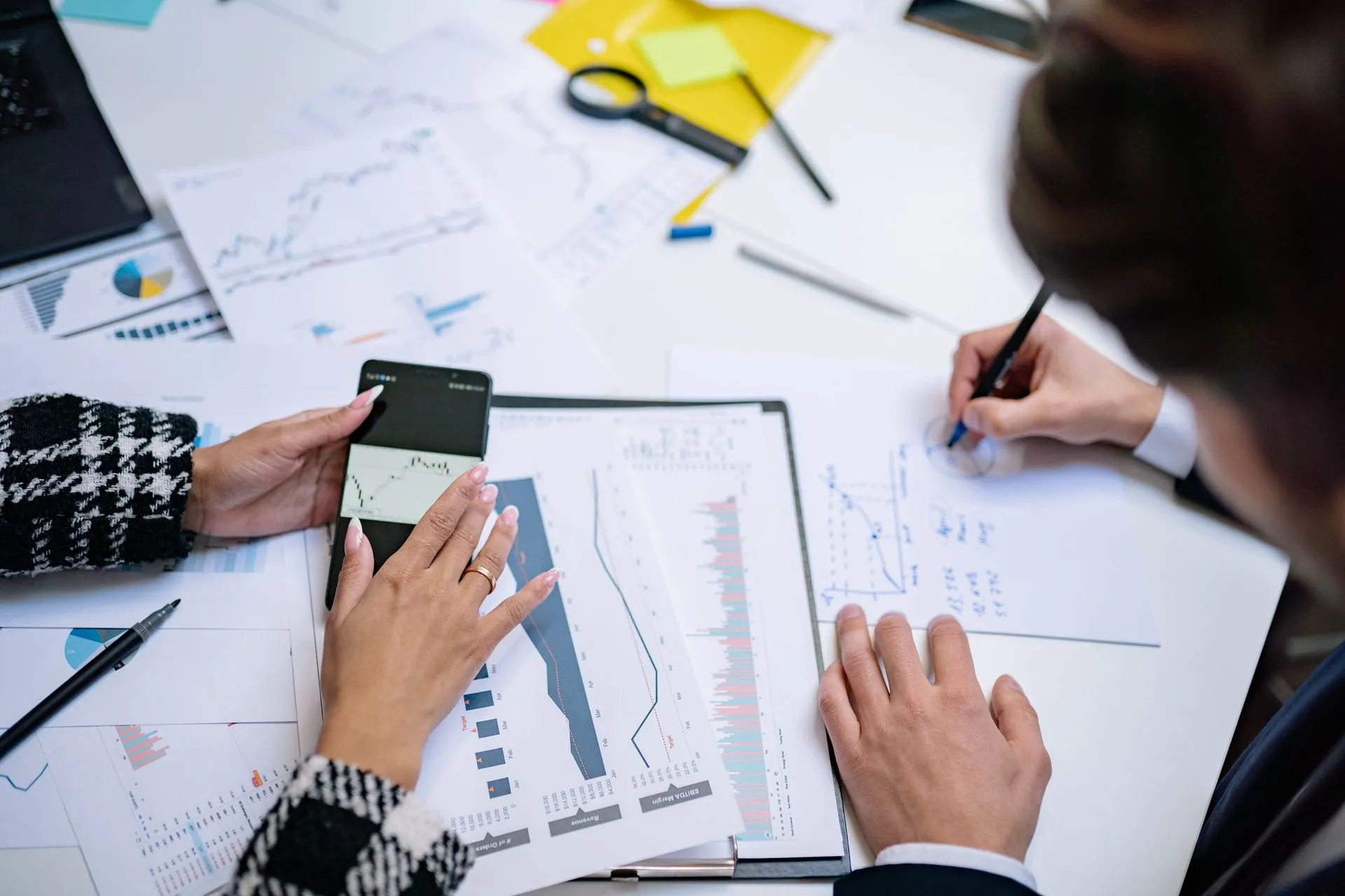 Team reviewing financial reports, charts, and data around a table